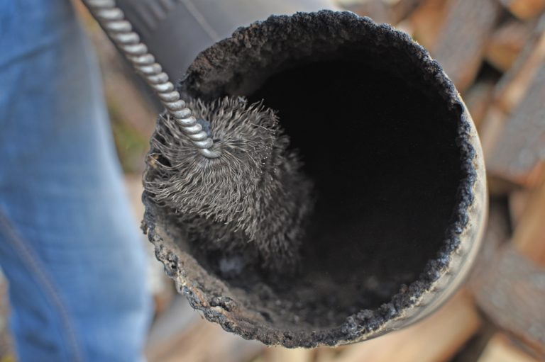 Man,Cleaning,Chimney,Pipe,Outside.,Cleaning,A,Wood,Burning,Stove.